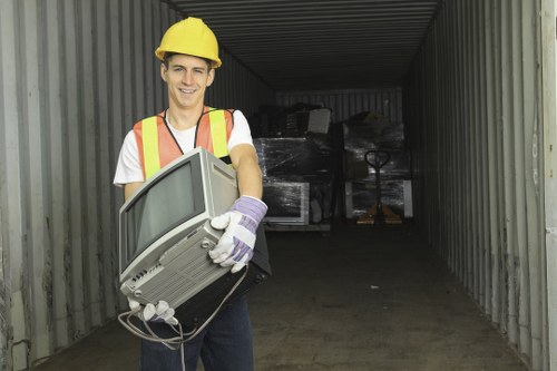 Workers loading a skip with protective gear